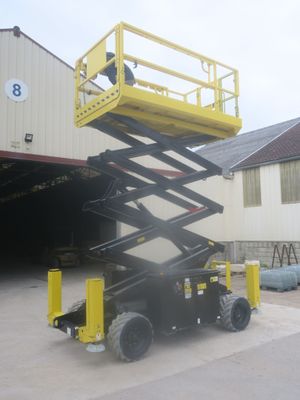 a yellow scissor that is parked in front of a building