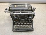 an old typewriter sitting on the floor in the room