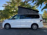 the white van is parked on the side of the road with its roof open