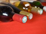 bottles of wine are lined up on a red table cloth