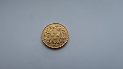 a close up of a gold coin on a white surface