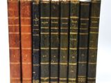 plusieurs vieux livres sont alignés sur une surface blanche