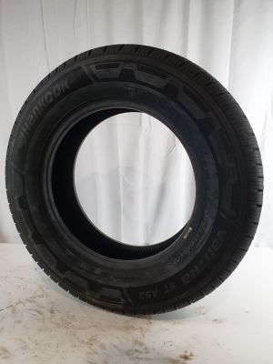 a close up of a tire on a white surface with a curtain in the background