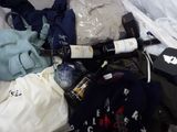un sac de vêtements et une bouteille de vin posés sur un lit