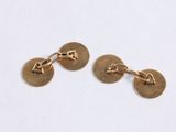 a pair of gold plated cufflinks on a white background