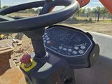 a close up of a tractor steering with a machine in the background