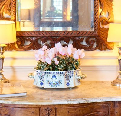 un vase avec des fleurs posé sur une table devant un miroir