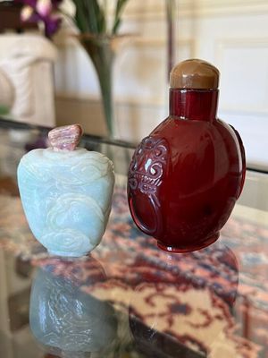 two vases sitting on a glass table next to each other