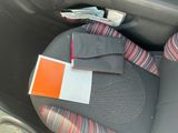 a car seat with a seat belt and a wallet on it