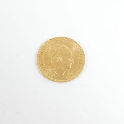 gros plan d'une pièce d'or sur une surface blanche