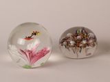 three glass paperweightes with flowers and a butterfly on them