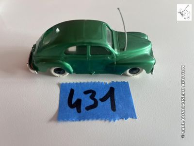 une petite voiture verte posée sur une table, à côté d'une feuille de papier bleue