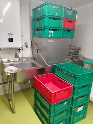 de nombreuses caisses vertes et rouges dans une cuisine équipée d'un évier