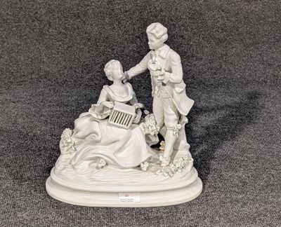 une figurine représentant un homme et une femme jouant d'un instrument de musique