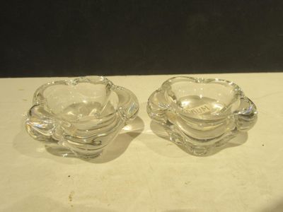 two clear glass dishes on a table with a black background