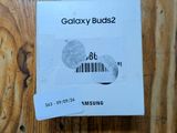 une photo de Samsung Buds 2 posés sur une table en bois