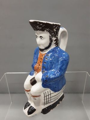 une figurine d'un homme assis sur une chaise