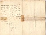 un vieux morceau de papier sur lequel on a écrit, posé sur une table