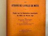 un livre orange posé sur une table près d'un mur blanc