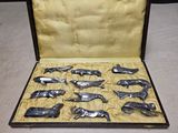 a lot of silver whale figurines in a case
