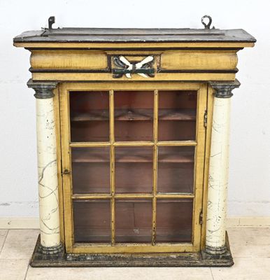 une vieille armoire en bois avec une porte vitrée et une poignée en métal