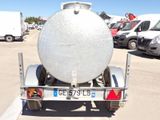 a truck with a tank on the back of it in a parking lot