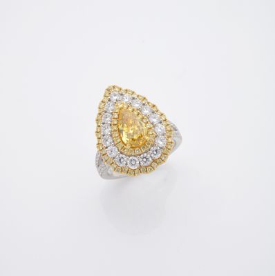 une bague sertie d'un diamant jaune et blanc sur fond blanc