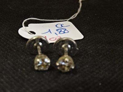 une paire de boucles d'oreilles posées sur une surface noire