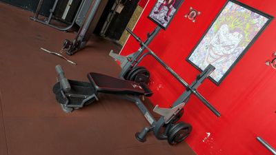 a gym room with a red wall and a gym equipment