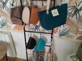 une photo montrant un présentoir de sacs à main et de sacs à bandoulière accrochés au mur