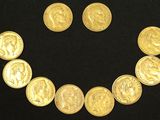 a smiley face made out of gold coins on a black surface