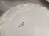 a white plate with a leaf on it sitting on a table