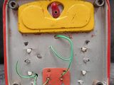 a yellow and red electronic device with wires attached to it