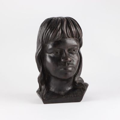 sculpture représentant la tête d'une femme aux longs cheveux sur fond blanc