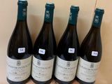 six bottles of wine are lined up on a wooden stand