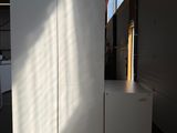 a large white refrigerator in a warehouse with the door open