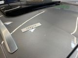 a sticker on the hood of a car that is parked in a showroom
