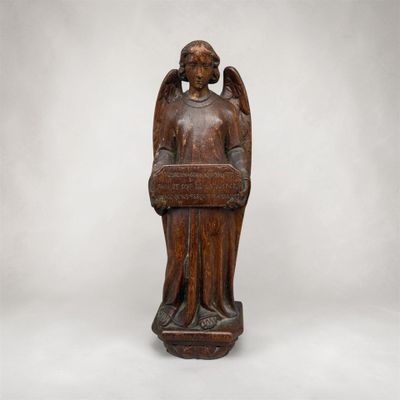 une statue en bois représentant un ange tenant un panier