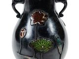 un vase noir orné d'un motif floral