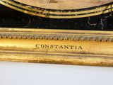 une photo d'une horloge posée sur une table, sur laquelle figurent des inscriptions
