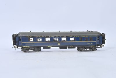 un wagon bleu qui se trouve sur les rails, dans la neige