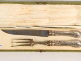 two knives and a fork in a green box