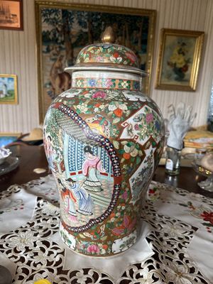 un grand vase posé sur une table recouverte d'un napperon