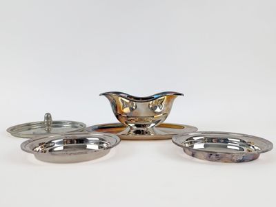 three silver plated dishes and a saucer on a white surface