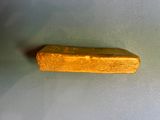 a piece of gold on a white surface