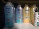 bottles of cleansers are lined up on a shelf in a bathroom