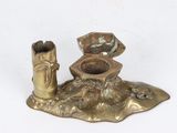 a gold candle holder with a figurine on top of it