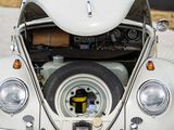 a white vw beetle parked on the street with its trunk open