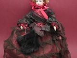 an old fashioned doll sitting on a red surface