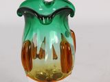 a glass vase with a green and yellow design on it